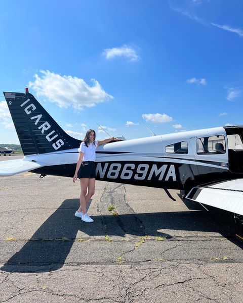Student standing by plane
